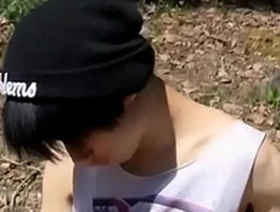 A small and pretty Asian boy pleasuring himself with anal beads outdoors.